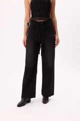 Pantalón de jean negro de pierna ancha con apliques de brillo y lazo desmontable.