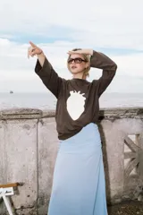 Buzo de algodón rojo con estampado de corazón en color rosa claro en el pecho, de manga larga y corte holgado.