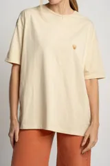 Remera color arena de algodón peinado, corte oversize y manga corta. Estampado pequeño de una concha en el pecho.