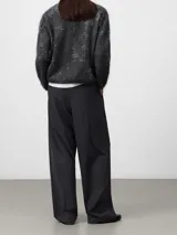 Jersey de punto cardado con textura suave y diseño jacquard sutil. Presenta cuello redondo, manga larga y un corte holgado con terminación redondeada.