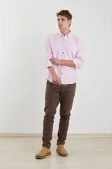 Camisa de vestir blanca de manga larga, con cuello abotonado, bolsillo frontal y botones en tono madera.