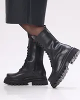 Borcego negro de cuero con cordones, caña media y suela track.