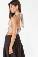 Top color blanco de lino italiano, con diseño de escote halter pronunciado, espalda descubierta y nudo frontal.