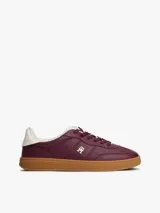 Zapatillas de corte bajo confeccionadas en piel napa brillante color bordó, con suela de goma color caramelo. Presentan insignia metálica del monograma TH en el lateral y detalle en blanco en el talón.