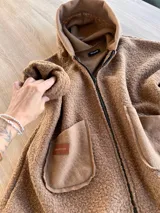 Campera negra de bouclé con cierre frontal y bolsillos de parche. Corte amplio y mangas largas.