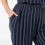 Pantalón ancho de punto crepé color azul marino con diseño de rayas verticales beige, de corte holgado y tiro alto, con bolsillos laterales.
