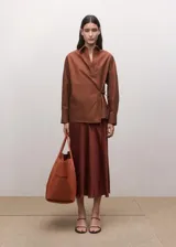 Camisa marrón de algodón con diseño cruzado, cierre lateral con lazo, cuello camisero y manga larga.