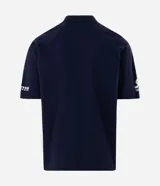 Remera polo de hombre azul marino con detalles en blanco, mangas cortas y corte boxy. Presenta estampas deportivas frontales con las leyendas "Radar" y "Anthem", además de recortes laterales en contraste y cuello con botones.