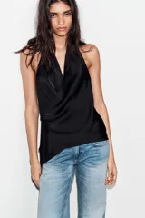 Top de satén con cuello halter, diseño drapeado en el frente y bajo asimétrico. Presenta espalda descubierta y cierre con lazada en el cuello.