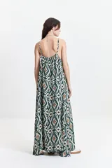 Vestido largo de silueta amplia con breteles finos y escote redondeado. Presenta un diseño fluido con frunces sutiles en el escote delantero y trasero, confeccionado en tela estampada con motivos geométricos.