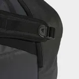 Bolso de viaje tipo duffel bag, color gris oscuro/negro, con múltiples compartimentos, bolsillo independiente para calzado y asas de mano, además de correa ajustable para llevar al hombro. Presenta detalles de cinchas y un parche con logo en el frente.