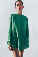 Camisa de viscosa ZW Collection con estampado de rayas verdes, cuello redondo mao, manga larga con puños anchos, pechera frontal y bajo asimétrico redondeado con cierre de botones.