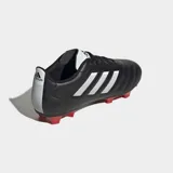 Championes de fútbol Adidas Goletto VIII diseñados para terreno firme. Presentan un exterior sintético negro con las icónicas tres tiras en blanco, costuras en el antepié para mejorar el control del balón y una suela con tapones rojos para tracción en superficies naturales.