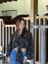 Camisa de lino con estampado orgánico en tonos oscuros, de silueta relajada, mangas amplias y detalle de nudo frontal.