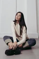 Sweater de punto con textura de ochos verticales, cuello redondo, mangas largas con puños acanalados y silueta relajada.