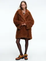 Tapado de textura tipo peluche en color marrón, con solapas anchas, mangas largas y corte holgado.