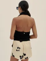 Top tejido color crema con escote halter y cuello camisero.