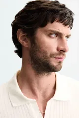 Polo de tejido canalé en color blanco, con cuello solapa y abertura frontal en V, de manga corta y corte regular.