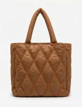 Cartera de eco cuero color marrón, con diseño capitoneado en rombos de gran relieve. Cuenta con un compartimento principal con cierre, amplios bolsillos laterales con botones imantados, asa de mano fija y correa larga regulable y removible. El forro interno es textil a tono con compartimentos organizadores.