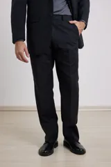 Traje de corte clásico compuesto por saco de dos botones y pantalón de vestir a juego. El saco presenta solapas tradicionales y bolsillos con solapa, mientras que el pantalón tiene un corte recto y formal.