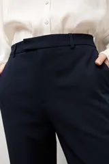Pantalón sastrero de corte flare, color azul marino, con bolsillos laterales y trabillas para cinturón.