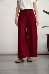Pantalón palazzo color bordó, de tiro alto con cintura elástica fruncida y cordón ajustable del mismo tono. Cuenta con bolsillos laterales tipo parche.
