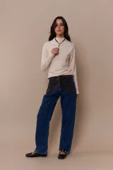 Pantalón de jean azul con parches en denim negro y azul oscuro.