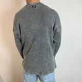 Buzo gris de tela waffle de algodón, corte oversize y cuello redondo.