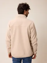 Campera de polar color verde militar, con cierre frontal completo, cuello alto y bolsillo en el pecho con cierre y detalle en tela técnica.