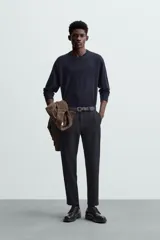 Pantalón chino de corte slim fit, confeccionado en tejido elástico. Presenta bolsillos frontales, bolsillos traseros de vivo con botón y cierre frontal con cremallera y botón.