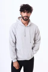 Buzo con capucha y bolsillo frontal tipo canguro, confeccionado en tela de felpa, con cordones ajustables en el cuello y puños elásticos.