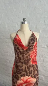 Vestido corto de microtul con estampado animal print y flores rojas, escote drapeado y tirantes finos.