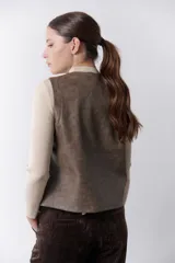 Chaleco marrón de simil cuero con bordado en color crema, cuello en V y cierre frontal con botones.