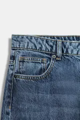 Jeans wide leg de tiro alto, color azul con efecto deslavado, cintura con trabillas, diseño de cinco bolsillos y cierre frontal con cremallera y botón metálico.