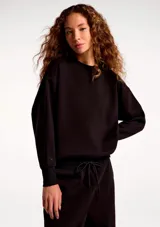 Buzo de cuello redondo con mangas largas y puños elastizados, de corte holgado y diseño minimalista.