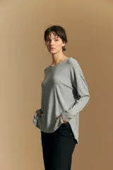 Remera de manga larga con silueta relajada y caída fluida, confeccionada en tejido suave con cuello redondo y aberturas laterales en el ruedo.