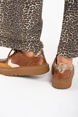 Zapatillas bajas de cuero color marrón con detalles en gamuza color tostado y talón en cuero dorado.