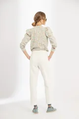 Pantalón recto color crudo, de tiro medio, confeccionado en canvas de algodón prelavado y suavizado. Presenta cierre frontal con gancho y botón interno, bolsillos laterales y traseros.