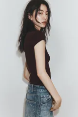 Camiseta slim fit color gris oscuro, con cuello redondo y manga sisa caída. Presenta un texto blanco en el delantero que dice "Main character Role".