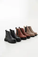 Botas tipo chelsea de cuero con suela track dentada y paneles elásticos laterales. Presentan costuras a contratono y tirador en la parte trasera.