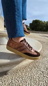 Zapatillas Dallas de cuero blanco, con detalles en gamuza beige y tiras laterales rosadas, suela de goma y diseño urbano.