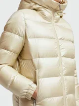 Campera puffer Moncler modelo Biron, color beige perlado, con capucha integrada, cierre frontal y bolsillos laterales con cierre. Presenta diseño acolchado horizontal y logo de la marca en la manga.