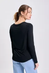 Remera básica de manga larga, color negro, con escote barco y calce al cuerpo.