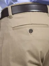 Pantalón de vestir azul marino, de corte recto, con bolsillos laterales y traseros. Se ajusta a la cintura con cinturón de cuero marrón.