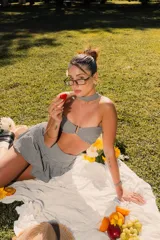 Top strapless de corte ajustado con estampado de cuadros vichy en blanco y negro. Presenta un cierre frontal con gancho metálico y un cuello tipo choker integrado en la misma tela.