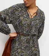 Vestido midi de corte fluido con estampado floral, escote en V con cordones ajustables, mangas largas abullonadas y falda con volados en el ruedo.