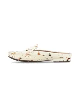 Zueco destalonado de cuero con pelo, diseño tipo mocasín abierto con estampa de animal print tipo vaca en tonos blanco, marrón y negro, y suela plana de goma.