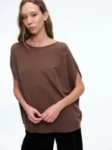 Top de tejido de punto color marrón con detalle de micro lentejuelas brillantes. Presenta un diseño de silueta amplia, cuello redondo y mangas cortas caídas.