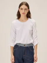 Remera de manga larga color blanco con cuello redondo y detalles fruncidos con lazos en las mangas.
