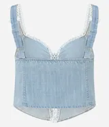 Top cropped de jeans celeste con escote corazón, breteles anchos y abertura frontal central abotonada. Los bordes del escote y la abertura están decorados con un ribete de encaje blanco tipo picot.